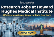 Research Jobs at Howard Hughes Medical Institute | Life Sciences Career Opportunity in New York Research Jobs at Howard Hughes Medical Institute | Life Sciences. Featured image for Biotecnika Global, titled "Research Jobs at Howard Hughes Medical Institute" with the subtitle "Life Sciences Career Opportunity in New York." The graphic is split, showing a modern laboratory with diverse scientists on the left and a sunset view of the New York City skyline with the Statue of Liberty and glowing DNA strands on the right. A large, golden "APPLY NOW" button is at the bottom.