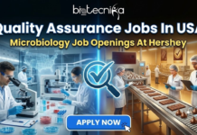 Quality Assurance Jobs In USA | Microbiology Job Openings At Hershey Quality Assurance Jobs In USA | Microbiology Jobs At Hershey. Featured image displaying "Quality Assurance Jobs In USA" and "Microbiology Job Openings At Hershey" with the Biotecnika Global logo at the top and an Apply Now button at the bottom, set against a professional corporate background.