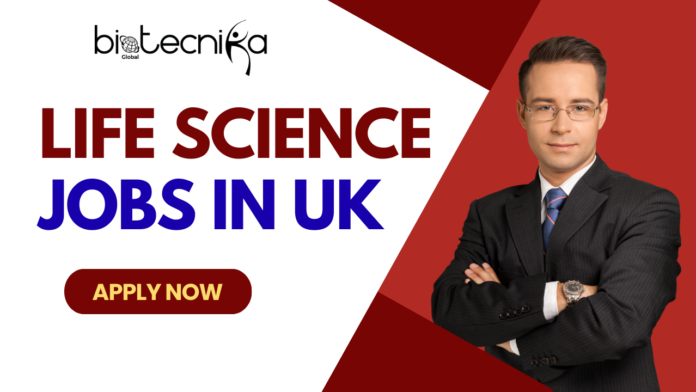 A promotional banner for Biotecnika Global, featuring the large text 'LIFE SCIENCE JOBS IN UK' in red and blue. On the right, a man in a black pinstripe suit and blue tie stands with crossed arms, against a background split between white and red with a Union Jack flag graphic. Below the text is a red button with 'APPLY NOW'.