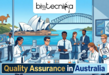 Quality Assurance Jobs in Australia | Apply For Technologist Roles at Kerry Quality Assurance Jobs in Australia Apply For Technologist Roles at Kerry. An illustration for "Quality Assurance in Australia" by Biotecnika Global, featuring a professional laboratory setting with a view of the Sydney Opera House and Harbour Bridge through a large window. In the foreground, a quality assurance professional in a lab coat is meticulously inspecting samples using high-tech equipment. The Biotecnika Global logo is positioned at the top, and the overall aesthetic combines high-end scientific research with iconic Australian scenery to create an attractive and unique featured image.