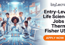 Thermo Fisher Hiring For Entry-Level Life Science Jobs in USA | Apply Now Entry-Level Life Science Jobs in USA – No Experience Needed Thermo Fisher Hiring. A promotional banner for "Entry-Level Life Science Jobs at Thermo Fisher USA," as advertised by Biotecnika Global. The left side features a stylized illustration of diverse scientists working in a modern laboratory with American flags and San Francisco landmarks in the background. The right side contains the Biotecnika Global logo, the job title text, and an orange "APPLY NOW" button.