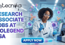 Explore Research Associate Jobs in USA at BioLegend | Freshers Apply Now Explore Research Associate Jobs in USA at BioLegend Freshers Apply Now. A featured image for a job advertisement titled "RESEARCH ASSOCIATE JOBS AT BIOLEGEND USA" in bold, gradient purple and blue text. The illustration features a female scientist in a white lab coat and safety glasses meticulously using a multichannel pipette on a microplate in a high-tech laboratory. Floating around her are glowing holographic displays of antibodies, viral structures, and a map of the United States. The Biotecnika Global logo is placed at the top left, and a bright, glowing blue "Apply Now" button is at the bottom center.