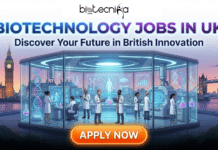 Latest Biotechnology Jobs in UK | Apply For Research Technician at University of Birmingham Latest Biotechnology Jobs in UK. A promotional graphic by Biotecnika Global titled "BIOTECHNOLOGY JOBS IN UK" in glowing blue and purple text, with the subtitle "Discover Your Future in British Innovation." The central illustration shows a futuristic, glass-walled laboratory filled with diverse scientists working with advanced equipment and holographic displays of DNA and data. The lab is situated outdoors at twilight, overlooking the River Thames with iconic London landmarks, including Big Ben, the Houses of Parliament, and Tower Bridge, visible in the background. At the bottom center is a large, glowing orange button with the white text "APPLY NOW."