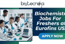 Freshers Job Alert | Biochemistry Jobs at Eurofins USA (Immediate Hiring) Freshers Job Alert Biochemistry Jobs at Eurofins USA (Immediate Hiring). A promotional graphic for "Biochemistry Jobs For Freshers at Eurofins USA," featuring the Biotecnika Global logo at the top. The left side shows a diverse group of young scientists in a modern laboratory setting with microscopes and other equipment, while the right side contains the text and an "APPLY NOW" button.