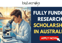 Fully Funded Research Scholarship in Australia | Apply For PhD in Nanotechnologies Fully Funded Research Scholarship in Australia Apply For PhD in Nanotechnologies. A promotional graphic with the Biotecnika Global logo at the top. On the left, an illustration shows a scientist looking into a microscope, set against a backdrop of Australian icons including the Sydney Opera House, a kangaroo, and a koala. On the right, large gold and white text reads, "Fully Funded Research Scholarship in Australia". Below it, smaller text says, "Your Gateway to Cutting-Edge Research & a Ph.D. Down Under!". At the bottom right is a gold "APPLY NOW" button.