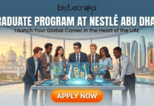 Graduate Program at Nestlé Abu Dhabi | Food Science & Life Sciences Apply Graduate Program at Nestlé Abu Dhabi. A vibrant recruitment banner for Biotecnika Global titled "GRADUATE PROGRAM AT NESTLÉ ABU DHABI" in bold white text, with the tagline "Launch Your Global Career in the Heart of the UAE." The illustration shows a diverse group of six enthusiastic young professionals in business attire gathered around a high-tech holographic table displaying sustainable packaging and beverage concepts. Through the large office windows, the Abu Dhabi skyline is visible, featuring the Sheikh Zayed Grand Mosque and modern skyscrapers at sunset. A large orange "APPLY NOW" button is at the bottom.