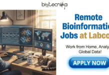Latest Remote Bioinformatics Jobs at Labcorp | Don’t Miss This Opportunity Latest Remote Bioinformatics Jobs at Labcorp Don't Miss This Opportunity. A featured job posting image by Biotecnika Global. At the top center is the Biotecnika Global logo. The left side shows a man working in a comfortable home office with a dual-monitor computer displaying bioinformatics data, including DNA sequences, protein structures, and a global map. A cat is sleeping on the desk next to a "Code & Coffee" mug. On the right side, large blue and gold text reads "Remote Bioinformatics Jobs at Labcorp", with smaller text below it saying "Work from Home, Analyze Global Data!". At the bottom right is a prominent blue "APPLY NOW" button.