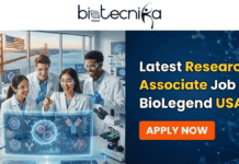 Latest Research Associate Job at BioLegend USA | Apply Before It’s Gone!! Latest Research Associate Job at BioLegend USA Apply Now. A promotional banner for "Latest Research Associate Job at BioLegend USA" by Biotecnika Global. At the top is the Biotecnika Global logo. On the left, a photo shows four diverse scientists in a lab, smiling and looking at a screen displaying a virus model, with the Golden Gate Bridge and an American flag in the background. On the right, against a dark blue background with molecular structures, large white and yellow text reads "Latest Research Associate Job at BioLegend USA," with an orange "APPLY NOW" button below.