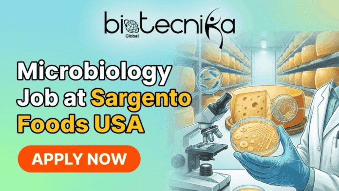 Microbiology Job Opportunity in USA Apply Today at Sargento Foods A professional featured image for a Microbiology Job at Sargento Foods USA. The design features the Biotecnika Global logo at the top center. On the right, a scientist in a lab coat and blue gloves holds a Petri dish, with a background showing shelves of aging cheese wheels and a microscope, symbolizing food microbiology. The left side displays the bold text