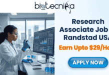 Latest Research Associate Job at Randstad USA | Earn Upto $29 per hour Research Associate Job at Randstad USA Earn Upto $29Hour. A job advertisement banner from Biotecnika Global. The top left shows the Biotecnika Global logo. The left half of the image features a Black woman in a lab coat, safety glasses, and gloves working with scientific equipment and a large computer monitor displaying data in a modern laboratory with a city skyline view. The right half of the image has large text that reads: 'Research Associate Job at Randstad USA' and 'Earn Upto $29/Hour'. Below the text is a blue button with the text 'APPLY NOW'.