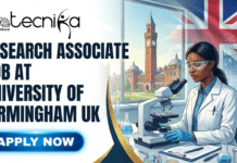 Research Associate Jobs in University of Birmingham | Cancer Research Opportunity in UK Research Associate Jobs in University of Birmingham | Cancer Research Opportunity in UK. A promotional banner for a job opening, featuring the text "RESEARCH ASSOCIATE JOB AT UNIVERSITY OF BIRMINGHAM UK" in large white letters. The image also includes the "biotecnika Global" logo in the top left corner and a blue "APPLY NOW" button in the bottom left. The background shows a female scientist in a lab coat and safety glasses using a microscope, with the University of Birmingham's Old Joe clock tower and a large Union Jack flag visible through a window.