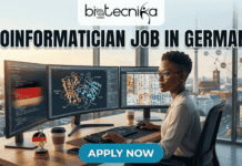 Bioinformatician Job in Germany | Cancer Research Role at German Cancer Research Center Bioinformatician Job in Germany Cancer Research Role at German Cancer Research Center. Job posting graphic from biotecnika Global. The bold title is "BIOINFORMATICIAN JOB IN GERMANY". A professional Black woman sits at a desk with three monitors, working on complex bioinformatics data including coding with German flag elements, protein structure visualization, and various data heatmaps. Through the window is a modern German city skyline. The graphic includes stylized gene network visualizations at the sides and a prominent "APPLY NOW" button at the bottom. A Biotecnika Global logo is at the top.