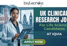 Clinical Research Jobs for Life science Candidates | IQVIA Hiring in UK Clinical Research Jobs in UK for Life science Candidates At IQVIA. A promotional banner with a logo at the top center that reads: "biotecnika Global." The left side features a photo of a young woman of color in a lab coat smiling confidently while holding a tablet displaying anatomical data, with a background of a laboratory that transitions to a window view of the London skyline, showing landmarks like The Gherkin and Big Ben. On the right side, large bold text states: "UK CLINICAL RESEARCH JOBS," with smaller text below reading: "For Life Science Candidates," and below that, "AT IQVIA." At the bottom is a prominent green "APPLY NOW" button. The right side has digital, blue-toned background graphics.