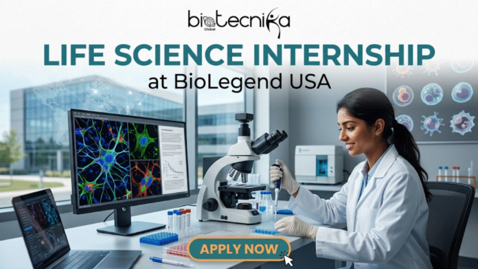 Life Science Internship at BioLegend USA | Product Development. A promotional banner with the biotecnika Global logo at the top center. Below the logo, large text reads 'LIFE SCIENCE INTERNSHIP' with 'at BioLegend USA' below that. The main scene depicts a young woman in a lab coat and blue gloves, smiling as she works with a micropipette to dispense liquid into a multi-well plate. She is seated at a desk cluttered with laboratory equipment, including a microscope and numerous test tubes. Behind her, a large computer monitor displays a vibrant, colorful fluorescent microscope image of a biological sample, showing intricate, branching structures with colors like blue, green, and red. In the background, through a large window, a modern biotech building is visible under a clear sky, with a world map pattern overlaid on the window's view. To the right of the desk, a specimen wall features various biological samples with scientific labels. At the bottom center, a prominent orange and teal button reads 'APPLY NOW' and has a mouse cursor clicking on it. The overall setting is professional, inviting, and high-tech.
