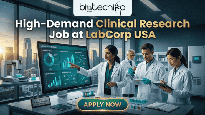 High-Demand Clinical Research Job at LabCorp USA for Life Science Graduates!. A promotional featured image from biotecnika Global with the headline 'High-Demand Clinical Research Job at LabCorp USA'. The image depicts a modern, high-tech laboratory with clean lines and high windows overlooking a large city skyline at dusk. A diverse team of four clinical research scientists (one woman in the foreground and three men in the background) in white lab coats are working. The central female scientist points to a large computer monitor displaying a detailed 'Clinical Trial Dashboard' with various charts, graphs, and molecular pathway diagrams. Below the screen, a plaque on the desk reads 'USA Clinical Research Excellence'. Other scientists are observing, pipetting into a well plate, and taking notes on a clipboard. At the bottom center, a prominent button with golden trim reads 'APPLY NOW'.
