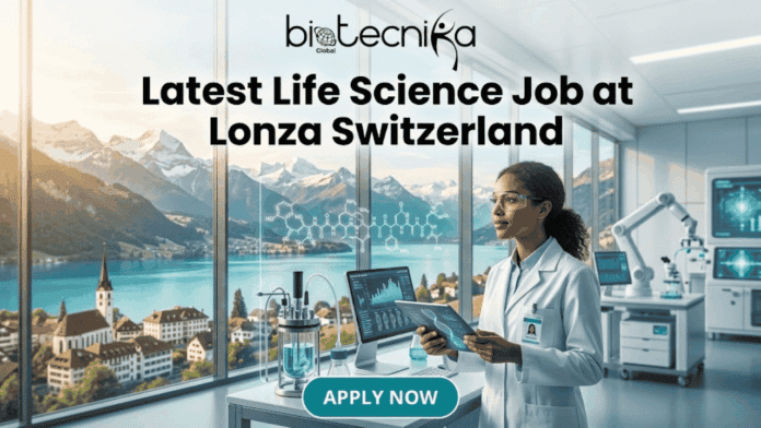 Latest Life Science Job in Switzerland Lonza Hiring PhD Candidates. A promotional image for a job posting from Biotecnika Global, featuring the large text headline 'Latest Life Science Job at Lonza Switzerland' in the upper center. Below the headline is a scene of a modern laboratory with a female scientist of color wearing safety glasses and a lab coat. She is holding a tablet that displays a DNA helix. She looks from the data towards a very large window that overlooks a picturesque Swiss mountain landscape with a lake and a small town. In the foreground is a lab workstation with a glass bioreactor and complex chemical formulas. To the right, a robot arm and high-tech monitors are visible. A prominent teal button at the bottom center reads 'APPLY NOW'.