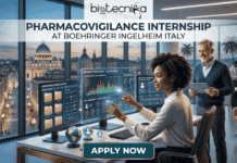 Boehringer Ingelheim Opens Pharmacovigilance Internship in Italy – Life Science Graduates Shouldn’t Miss This! Pharmacovigilance Paid Internship at Boehringer Ingelheim Italy. A featured image for a job page, depicting a high-tech and aspirational scene. Set in a modern office with futuristic transparent data screens and a globe on the desk, a smiling young woman is actively interacting with charts and anonymized patient case files. Behind her, a smiling older male mentor observes her work, holding a tablet. The large background window offers a panoramic view of Rome at dusk, prominently featuring St. Peter's Basilica. The image includes the Biotecnika Global logo, the main text "PHARMACOVIGILANCE INTERNSHIP AT BOEHRINGER INGELHEIM ITALY," and a large teal "APPLY NOW" button at the bottom center.