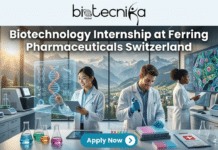 Paid Biotechnology Internship at Ferring Pharmaceuticals Switzerland | Apply Today!! Paid Biotechnology Internship at Ferring Pharmaceuticals Switzerland | Apply Today!! A promotional featured image for a biotechnology internship at Ferring Pharmaceuticals Switzerland. The graphic features a high-tech illustration of diverse male and female scientists collaborating in a modern laboratory with a backdrop of the Swiss Alps visible through a window. The top of the image displays a dark blue banner with the text "Biotechnology Internship at Ferring Pharmaceuticals Switzerland" and the Biotecnika Global logo. Scientific equipment like microscopes, DNA models, glowing computer screens, and test tubes are present throughout the lab setting. A prominent teal "Apply Now" button with a white arrow is at the bottom of the image.