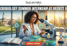 Microbiology Summer Internship at Reckitt USA | Apply Before It’s Gone Microbiology Summer Internship at Reckitt USA Apply Before It's Gone. A promotional banner for a microbiology summer internship at Reckitt USA, featuring the Biotecnika Global logo at the top. The central image shows a smiling Black woman in a lab coat and glasses, looking into a microscope at a laboratory bench. She uses a micropipette to work on petri dishes, some containing bacterial cultures forming the shape of the USA map, with glowing cartoon microbes floating around. The lab bench also holds an open textbook, a DNA model, beakers, and an American flag. Background windows look out onto a university campus on the left and a modern city skyline on the right. An orange 'APPLY NOW' button is at the bottom center.
